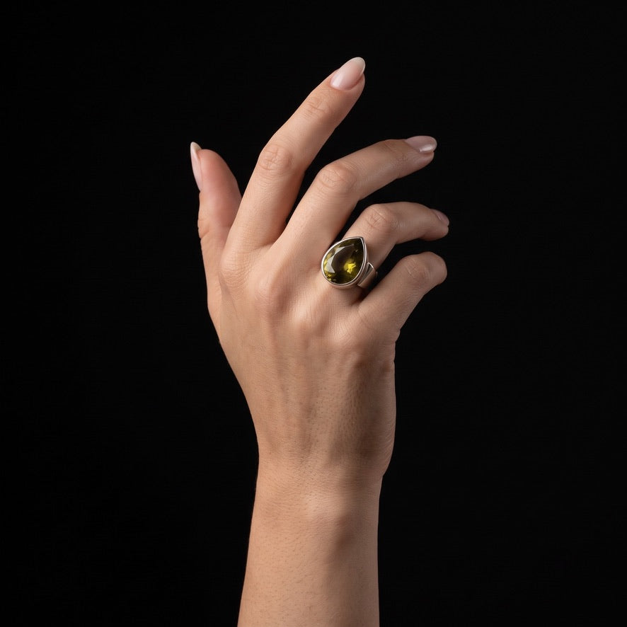 Golden brown volcanic glass teardrop ring in 925 sterling silver worn on hand