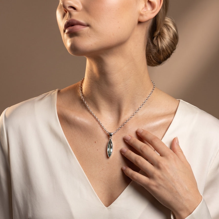 Sea blue volcanic glass navette pendant in 925 sterling silver worn on necklace
