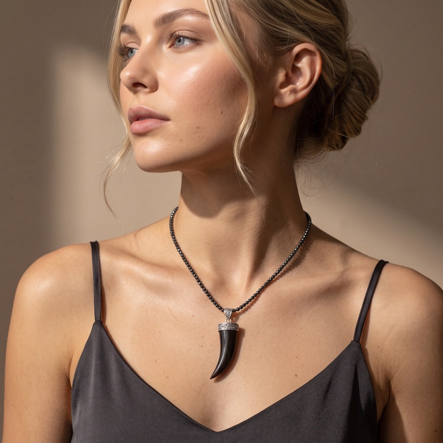 Woman wearing black wood horn pendant with ornate sterling silver detailing