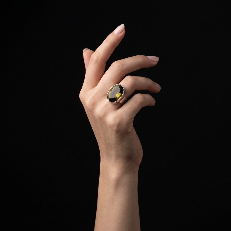 Woman wearing gold-brown oval volcanic glass statement ring in 925 sterling silver