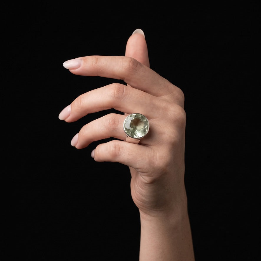 Woman wearing light green round volcanic glass statement ring in 925 sterling silver