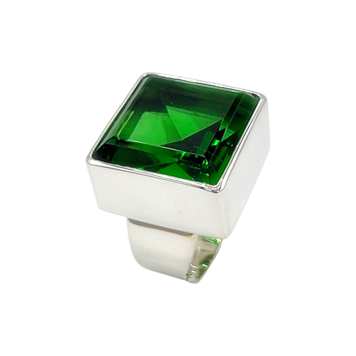 Angled view of adjustable emerald green volcanic glass ring with polished sterling silver setting