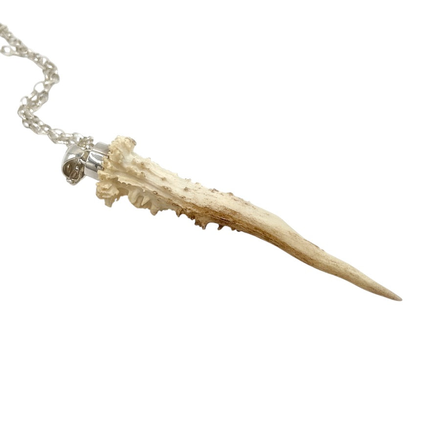 Side view of natural deer antler pendant showing irregular organic texture